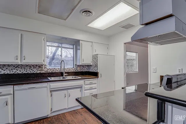 a kitchen with stainless steel appliances granite countertop a sink stove and cabinets