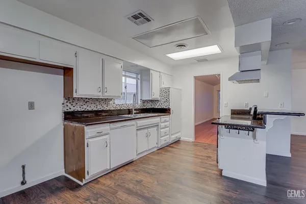 a kitchen with stainless steel appliances a sink dishwasher stove and refrigerator