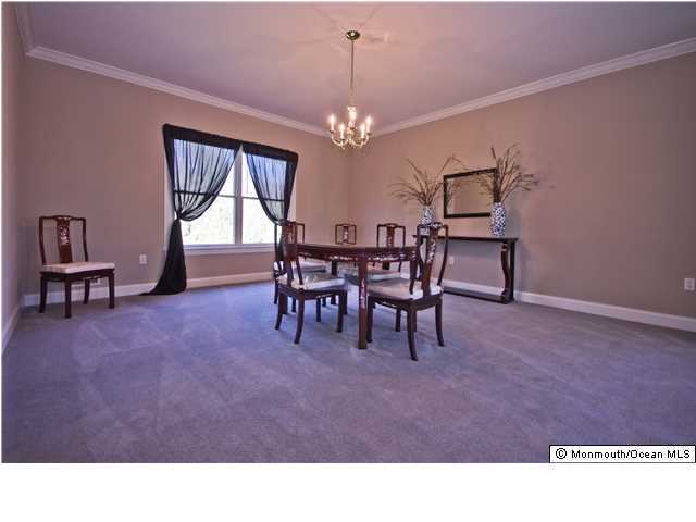 445 Iron Bridge Road Freehold, NJ 07728 - Photo 5 of 19 a living room with furniture a chandelier a rug and a large window