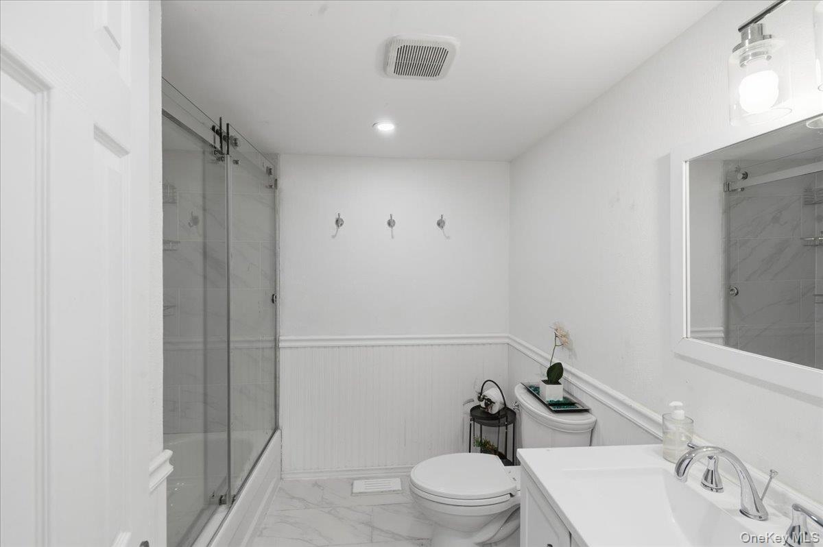 30 George Drive Mastic, NY 11950 - Photo 19 of 26 a bathroom with a sink a toilet and shower
