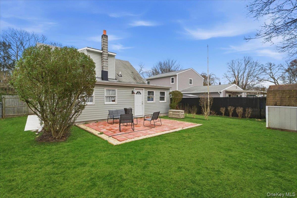 30 George Drive Mastic, NY 11950 - Photo 23 of 26 a front view of house with a garden and patio