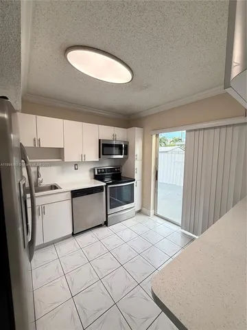 a kitchen with stainless steel appliances a refrigerator sink and cabinets