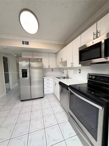 a kitchen with a sink a stove and cabinets