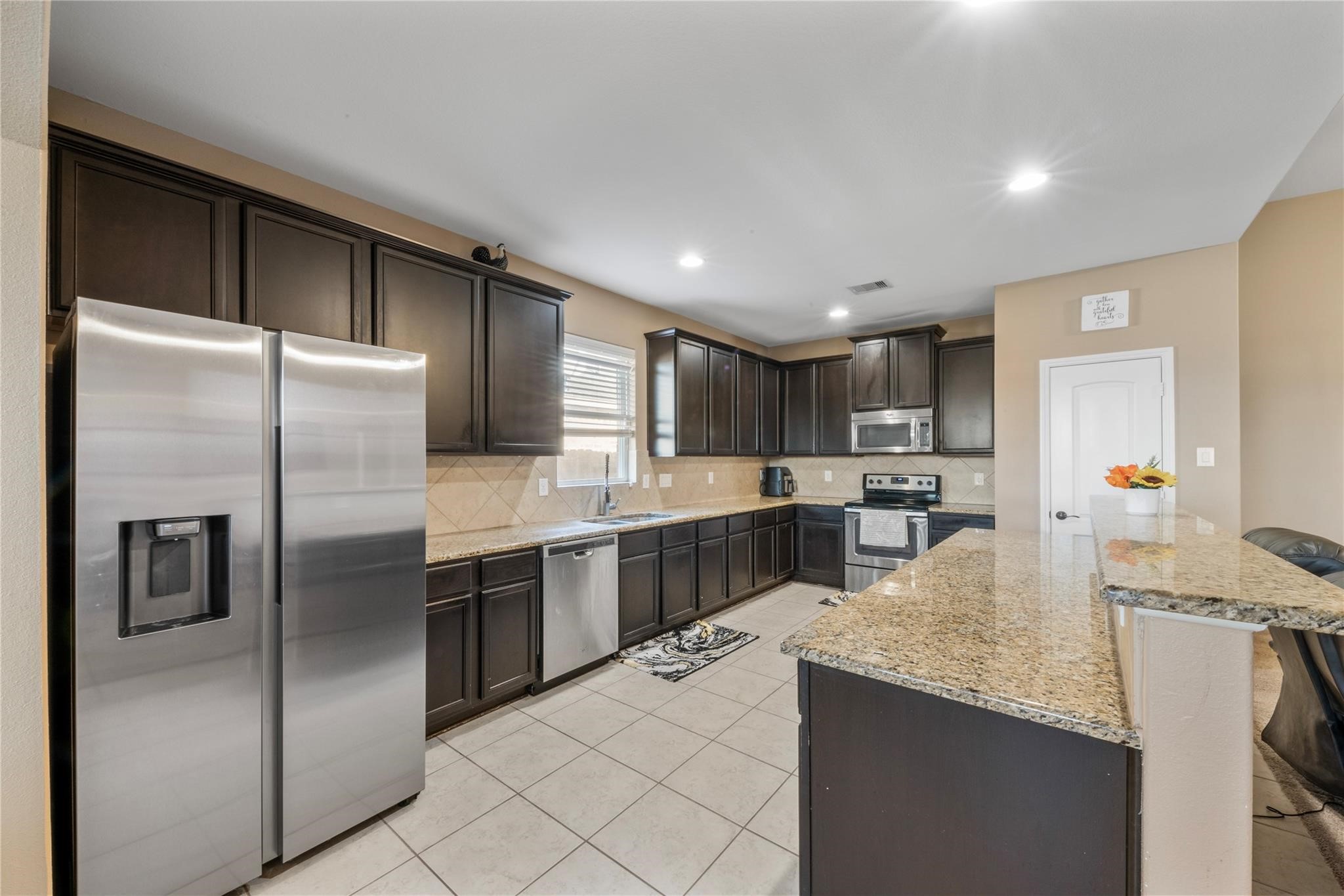 22907 Gentle Shadow Drive Hockley, TX 77447 - Photo 9 of 27 Modern and practical kitchen with ample cabinet space and a layout designed for efficiency, seamlessly connected to the dining and living areas.