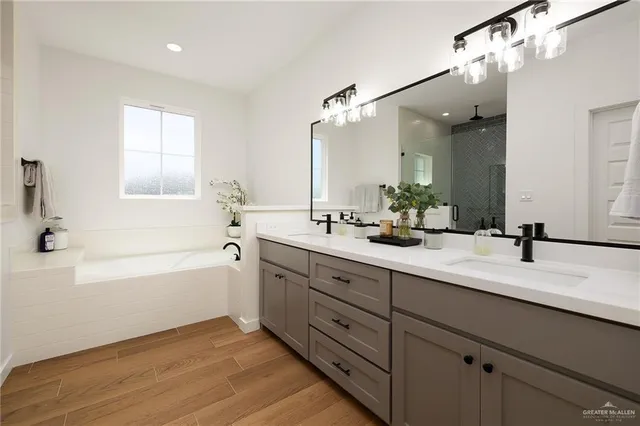 a bathroom with a tub a sink and mirror