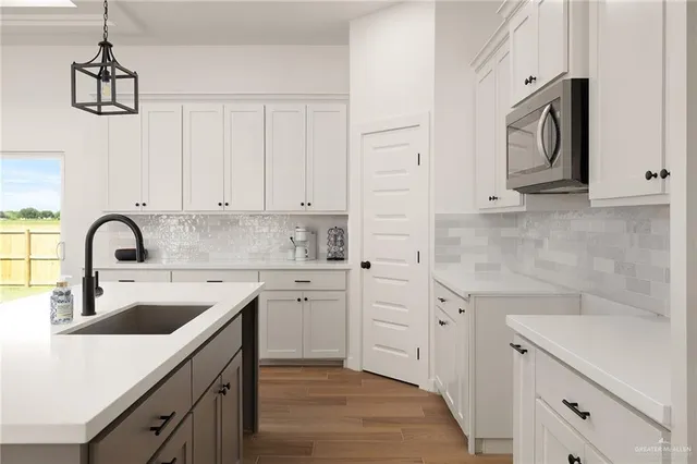 a kitchen with white cabinets sink and dishwasher