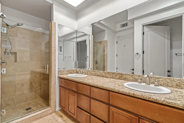 a bathroom with a granite countertop sink mirror and shower