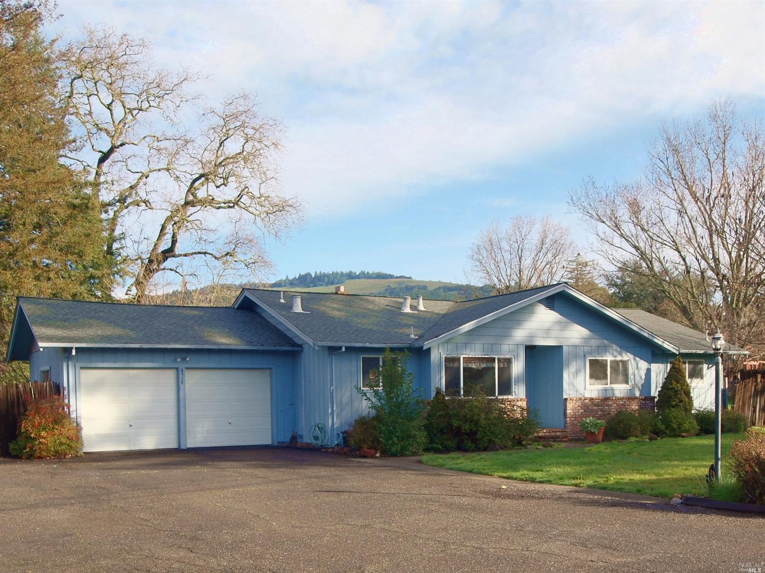 4519 Ranchette Road Santa Rosa, CA 95409 - Photo 1 of 1 a front view of a house with a garden and trees