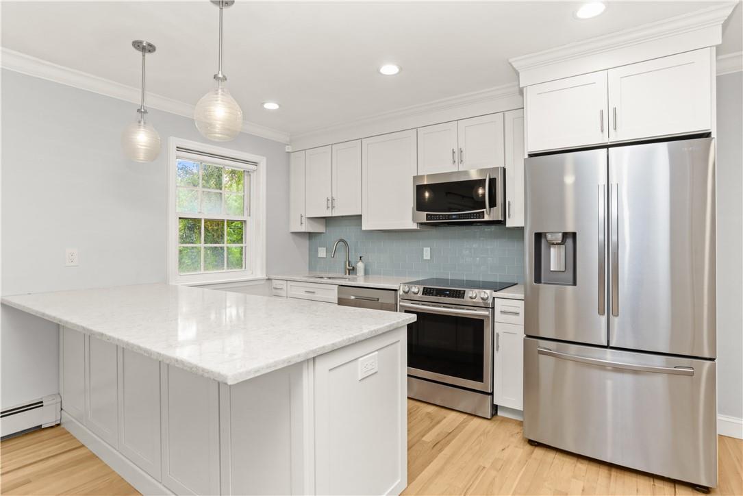 a kitchen with stainless steel appliances a refrigerator sink and microwave