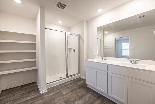 a bathroom with a double vanity sink mirror and shower