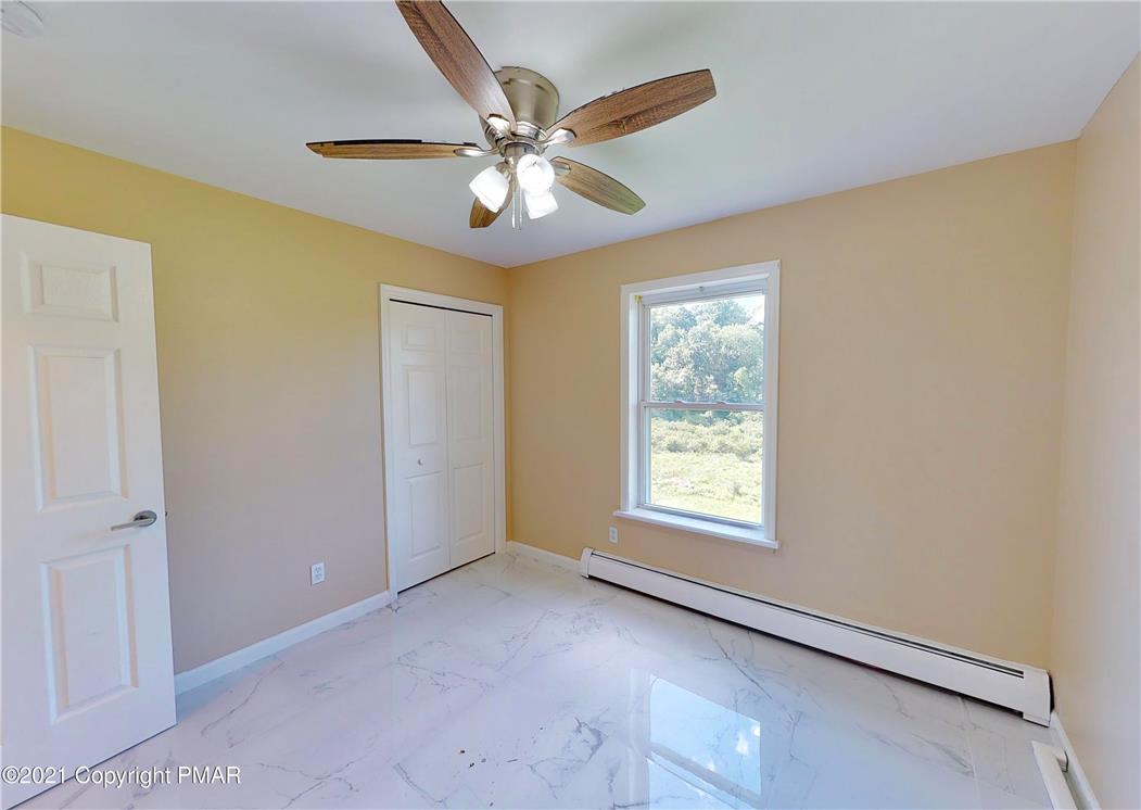 1110 Misty Ridge East Stroudsburg, PA 18302 - Photo 31 of 43 A quiet retreat with a classic ceiling fan, offering peaceful views of verdant trees and abundant light.