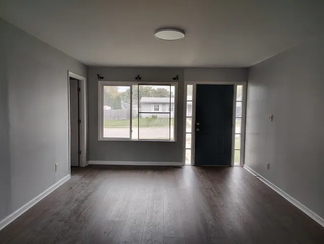 a kitchen with cabinets wooden floor and stainless steel appliances