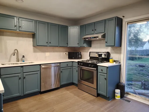 a kitchen with a sink a stove and cabinets