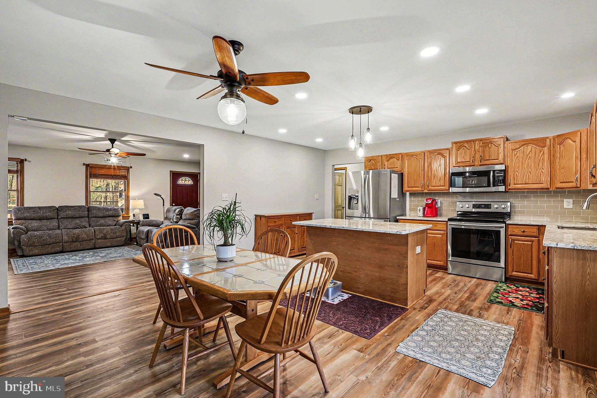 8318 Diamond Hill Road Warrenton, VA 20186 - Photo 5 of 88 a kitchen with stainless steel appliances kitchen island granite countertop a table chairs and a refrigerator