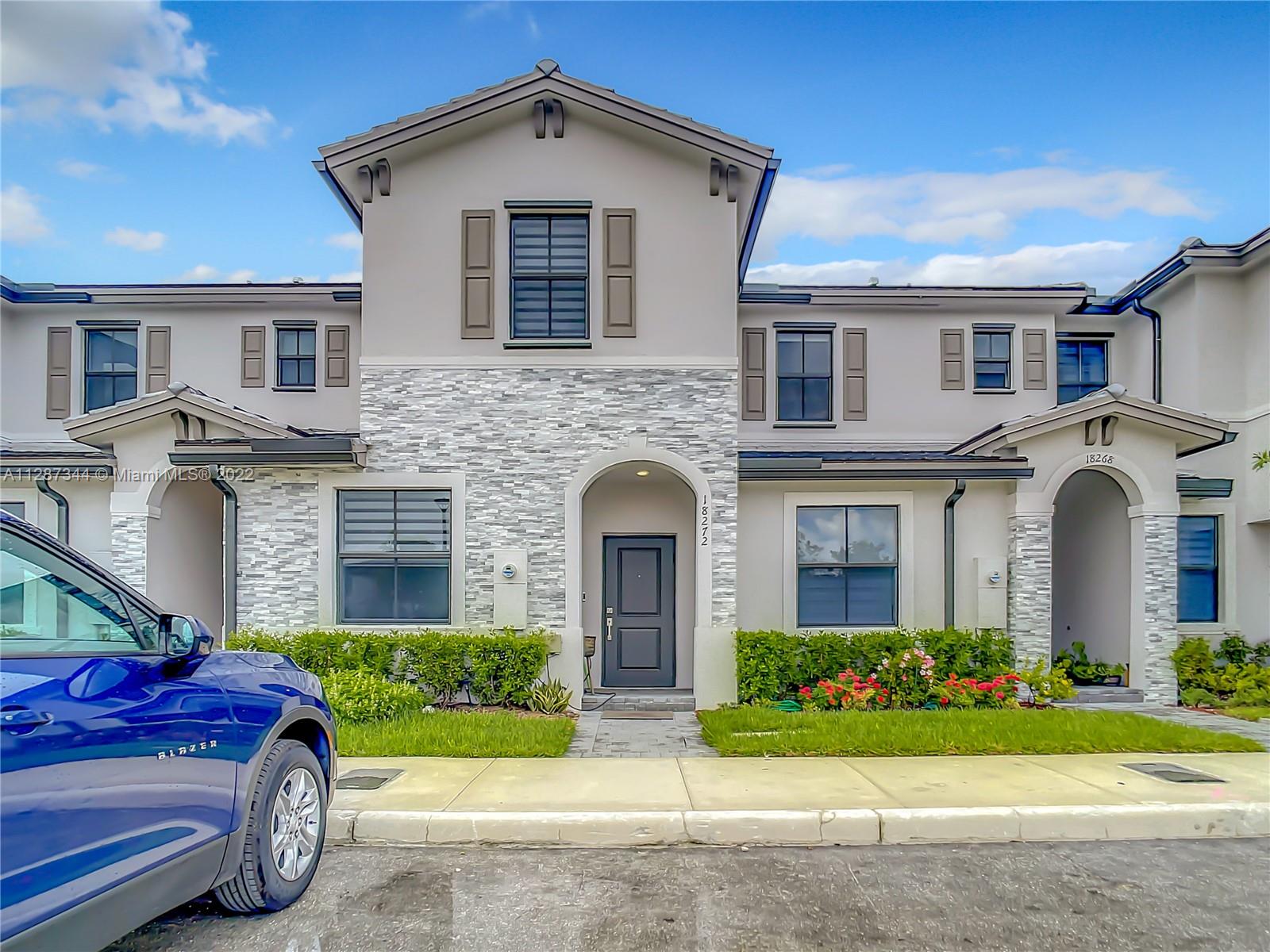 18272 Southwest 148th Road, Unit 18272 Miami, FL 33187 - Photo 1 of 19 a front view of a house with garden