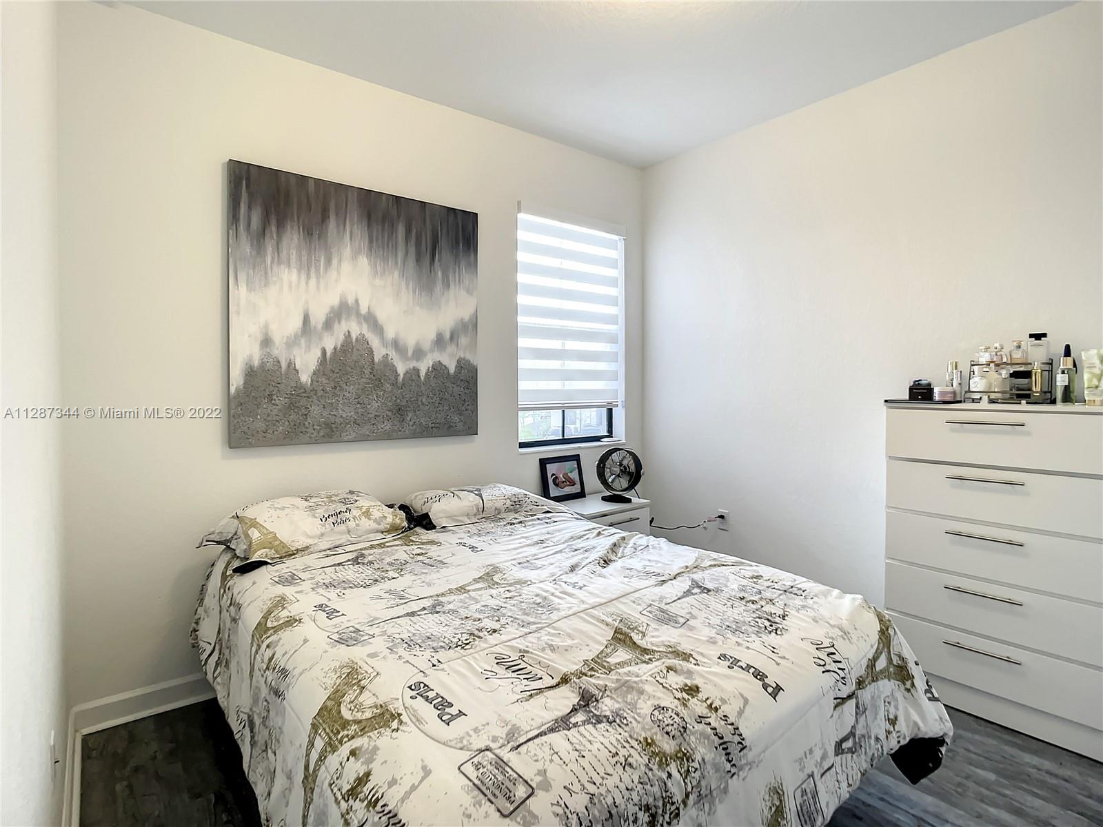 18272 Southwest 148th Road, Unit 18272 Miami, FL 33187 - Photo 11 of 19 a bedroom with a bed and a painting on the wall