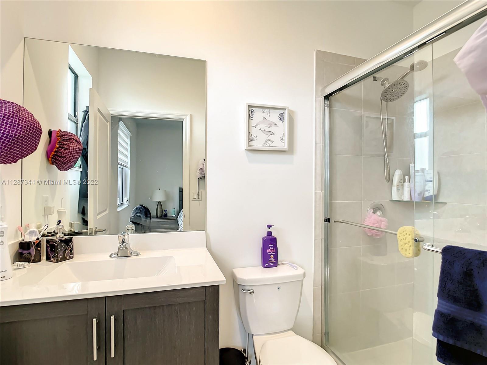 18272 Southwest 148th Road, Unit 18272 Miami, FL 33187 - Photo 15 of 19 a bathroom with a sink vanity mirror and toilet