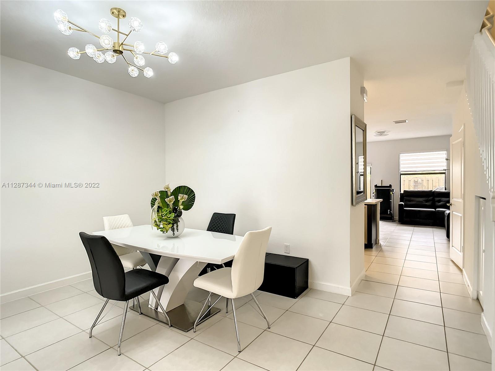 18272 Southwest 148th Road, Unit 18272 Miami, FL 33187 - Photo 5 of 19 a view of a dining room with furniture and a chandelier fan