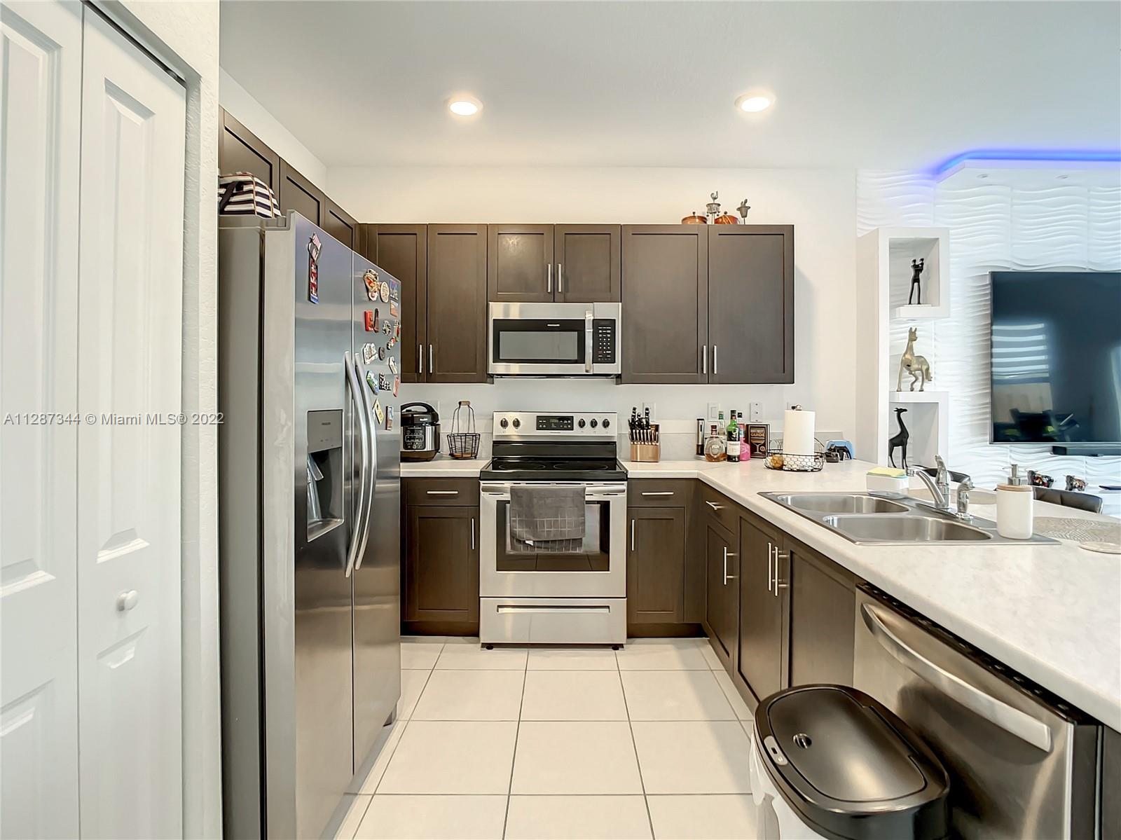 18272 Southwest 148th Road, Unit 18272 Miami, FL 33187 - Photo 6 of 19 a kitchen with a sink cabinets and stainless steel appliances