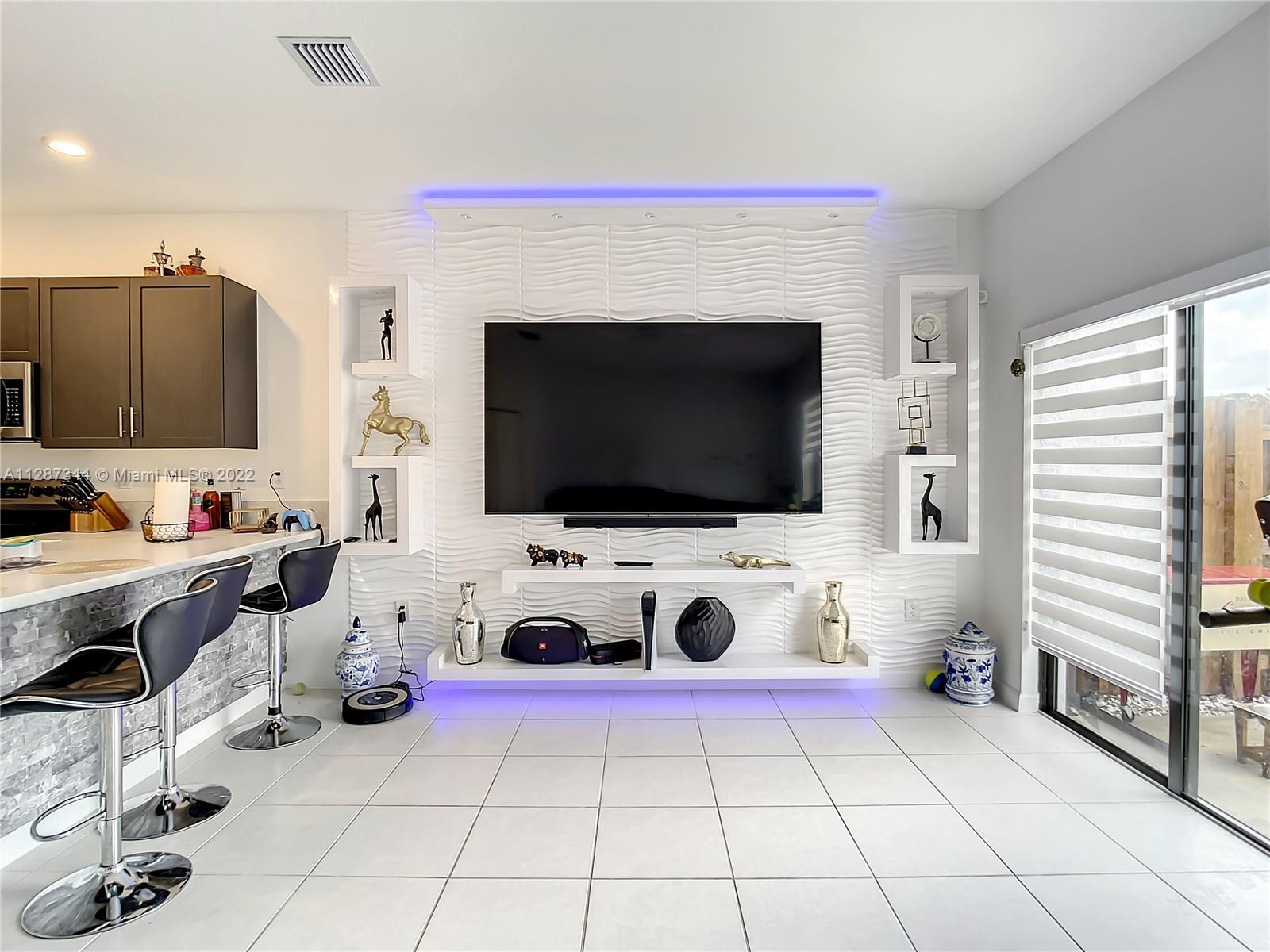 18272 Southwest 148th Road, Unit 18272 Miami, FL 33187 - Photo 7 of 19 a living room with furniture and a flat screen tv