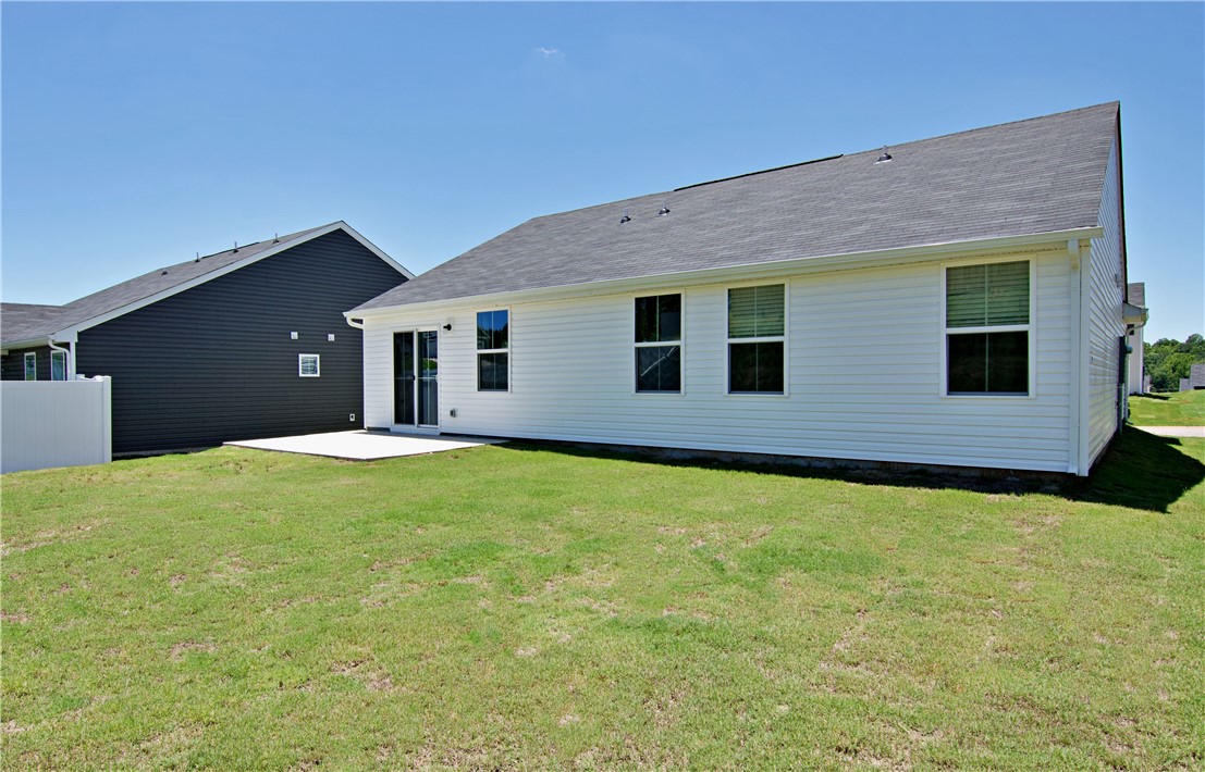 723 Peridot Way Westminster, SC 29693 - Photo 34 of 45 A spacious grassy yard extends from the rear of the home, featuring a concrete patio.