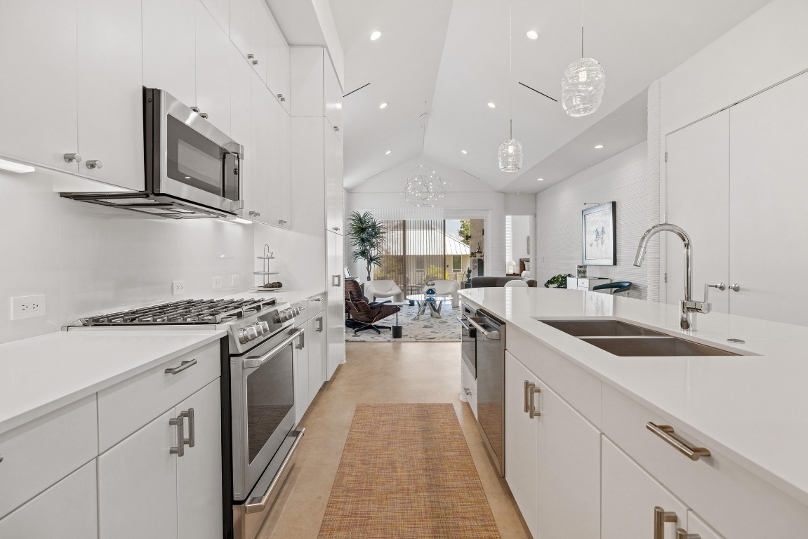 213 Lone Ranger Trail Georgetown, TX 78628 - Photo 13 of 26 a kitchen with stainless steel appliances granite countertop a sink stove and cabinets