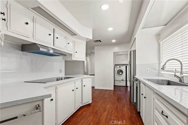 a kitchen with cabinets and wooden floor