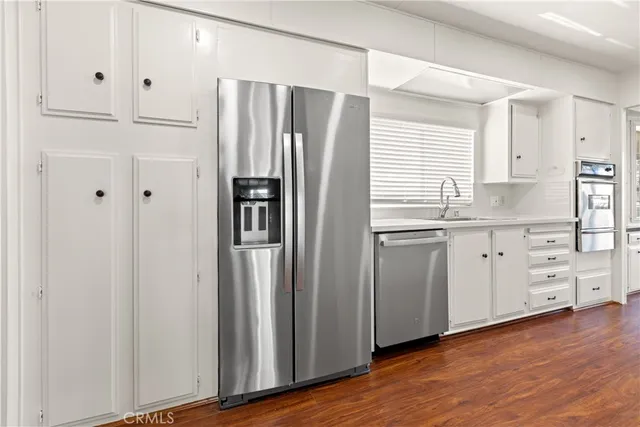 a kitchen with stainless steel appliances a refrigerator sink and cabinets