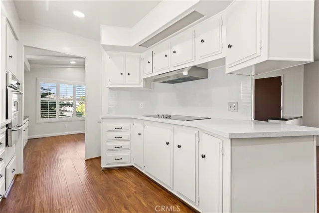 a kitchen with stainless steel appliances white cabinets and a window