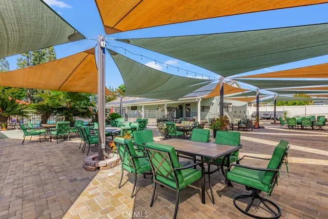 a view of a patio with a table and chairs under an umbrella