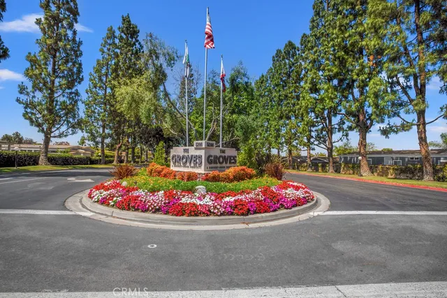 a tall white house with lots of trees in the background