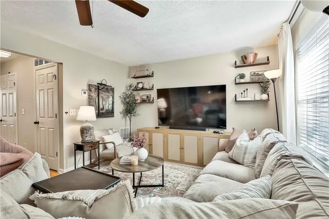 a living room with furniture ceiling fan and a window