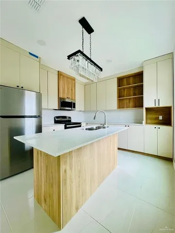 a kitchen with stainless steel appliances a sink stove and refrigerator