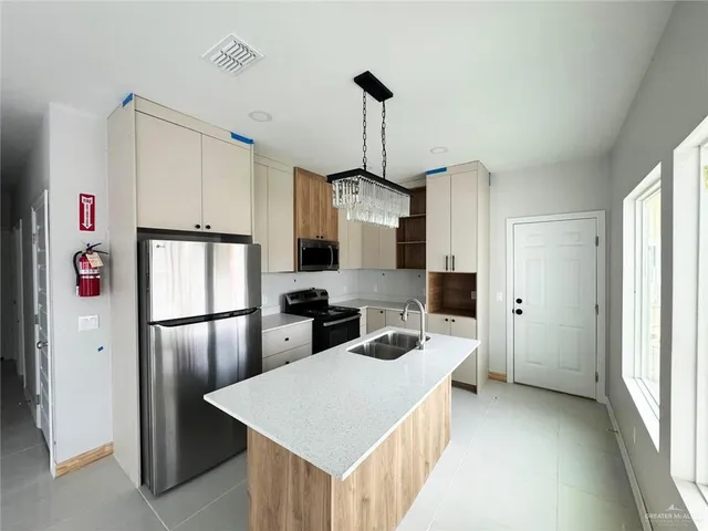a kitchen with refrigerator a stove a sink dishwasher and white cabinets with wooden floor