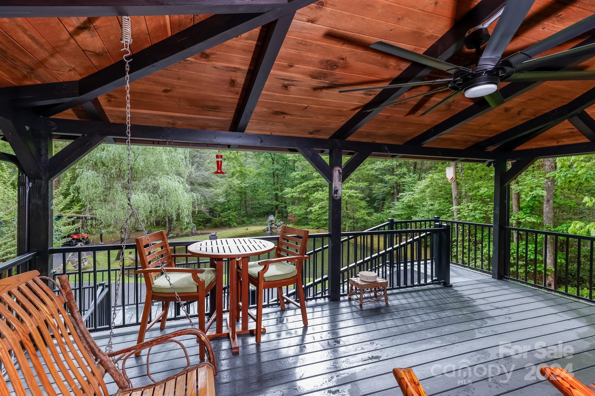 997 Proctor Road Lake Lure, NC 28746 - Photo 5 of 43 a view of a patio with wooden floor a yard tables and chairs