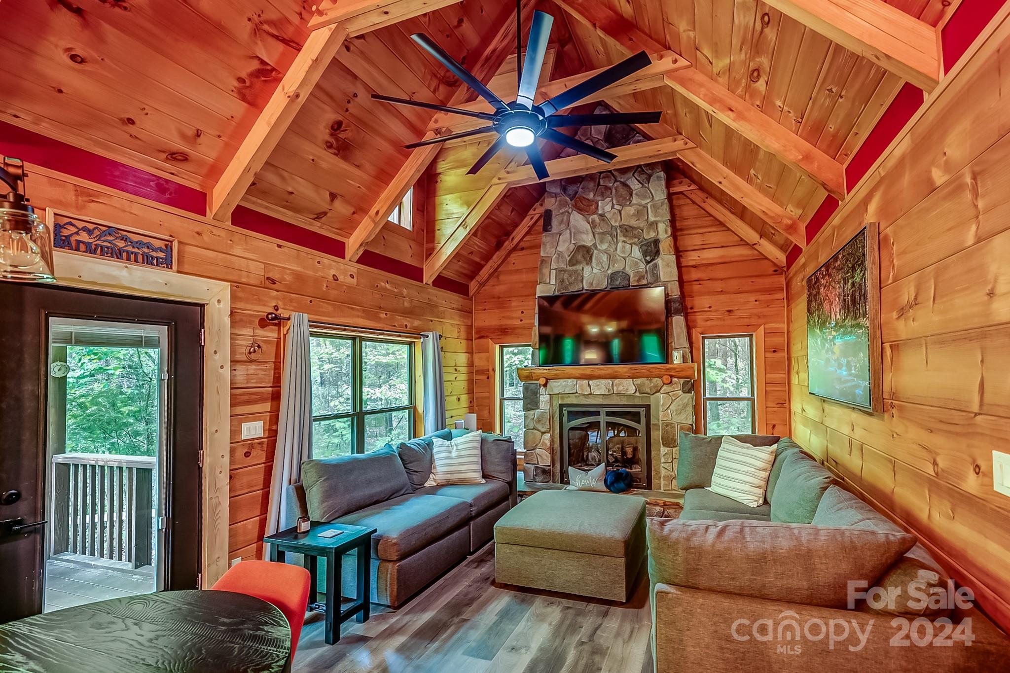 997 Proctor Road Lake Lure, NC 28746 - Photo 8 of 43 a living room with furniture a fireplace and a floor to ceiling window