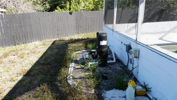 a view of a backyard with plants and wooden fence