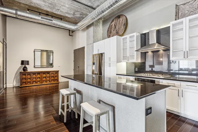 a kitchen with stainless steel appliances a refrigerator and wooden floor