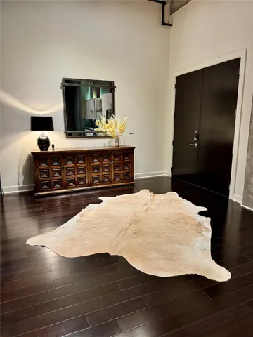 a living room with stainless steel appliances furniture a flat screen tv and a table