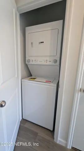 a utility room with wooden floor washer and dryer
