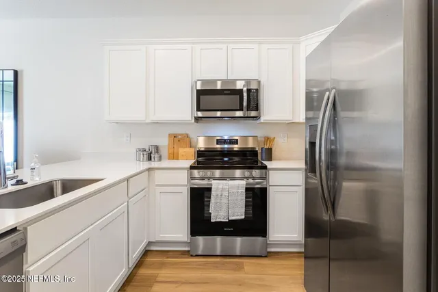 a kitchen with a sink stainless steel appliances and cabinets