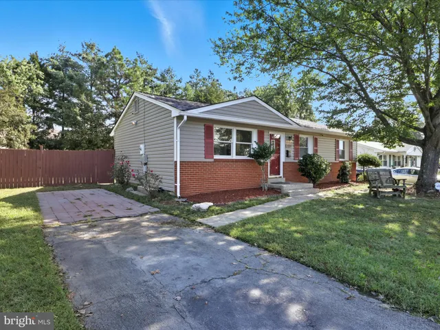 a view of a yard in front of a house with large tree