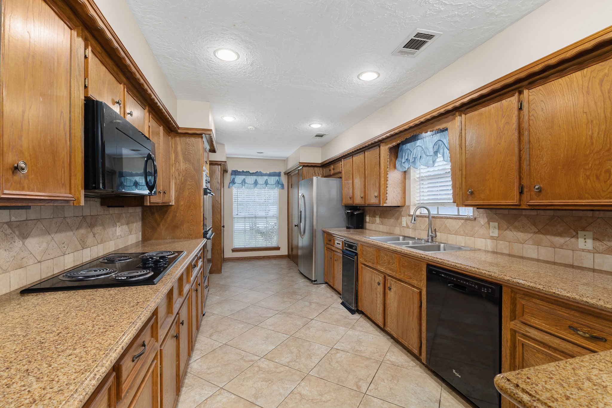 460 Dover Lane Spring, TX 77373 - Photo 13 of 47 a kitchen with stainless steel appliances granite countertop a stove a sink and a microwave