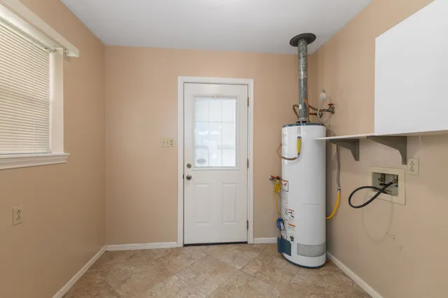 a view of an empty room with chandelier fan and fire place