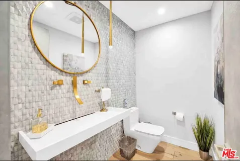 a bathroom with a granite countertop sink mirror vanity and toilet