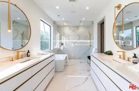 a bathroom with a granite countertop sink mirror and bathtub