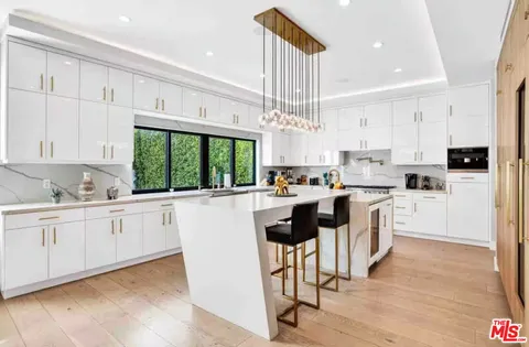 a kitchen with white cabinets and white appliances