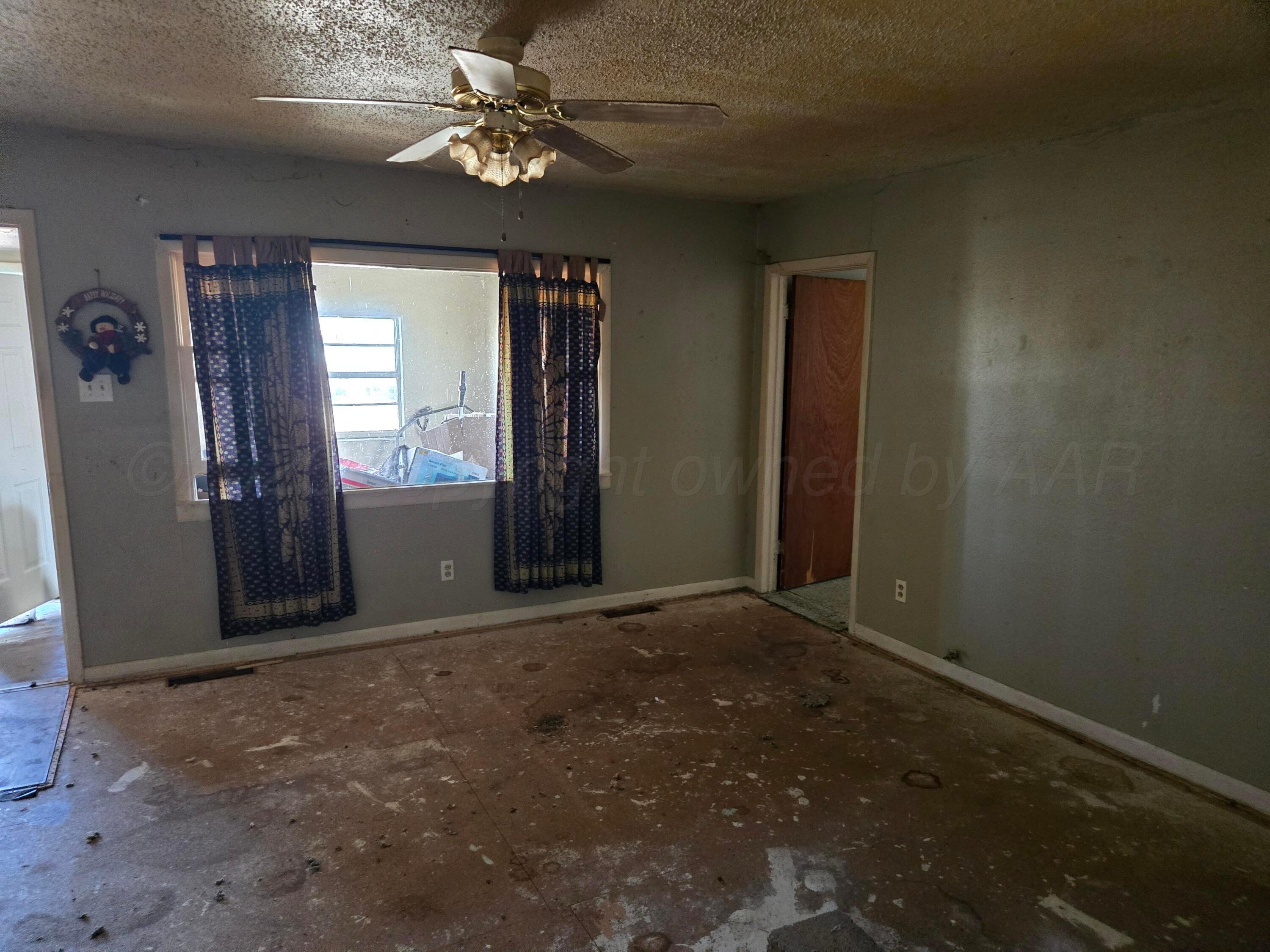 421 North 8th Street Memphis, TX 79245 - Photo 8 of 40 an empty room with windows and fan