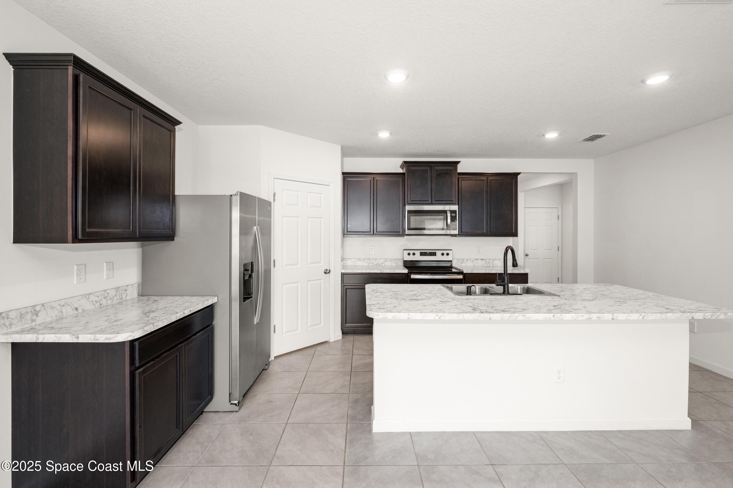 4641 Talbot Boulevard Cocoa, FL 32926 - Photo 12 of 14 a kitchen with a appliances a sink and a refrigerator