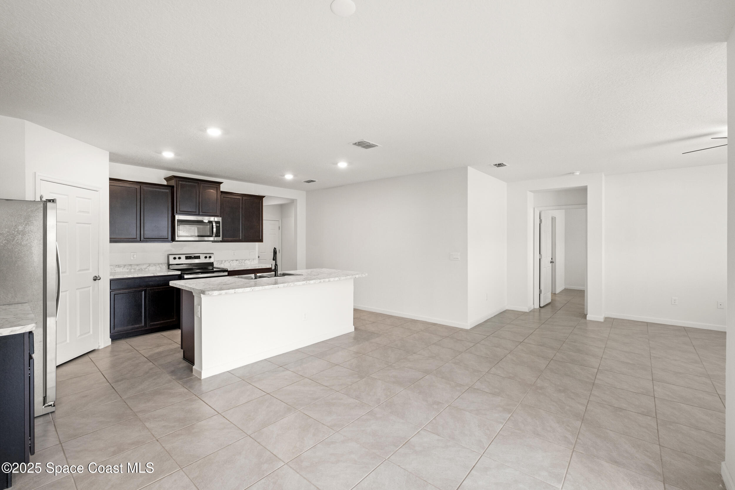 4641 Talbot Boulevard Cocoa, FL 32926 - Photo 13 of 14 a large kitchen with kitchen island a sink a stove and a refrigerator